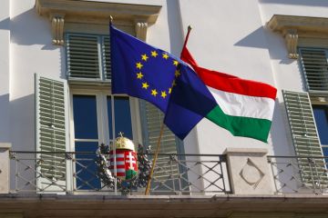 Hungary and EU flags perched outside a balcony