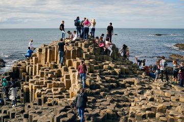 Crowd of people on the Giant's Causeway, Northern Ireland, illustrating how students may still look elsewhere to study if the Maximum Student Number (MaSN) cap was relaxed.