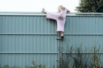 Girl climbing metal fence outdoor