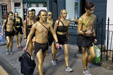 People with gold spray paint on their bodies