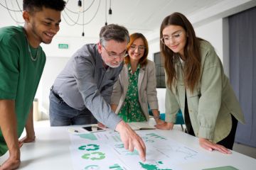 A businessman points at a chart while brainstorming with colleagues, symbolising green business expertise 