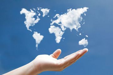 Hand holding world map drawn in clouds Hand holding world map drawn in clouds
