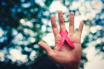 Hand holding AIDS ribbon Hand holding AIDS ribbon