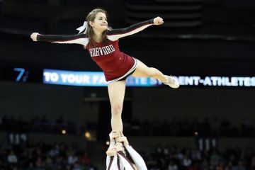 Harvard Crimson cheerleader (Harvard University) being held aloft