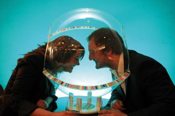 Two volunteers try out the 'social sphere' for two - plastic speech bubbles that allow you to hold a private conversation in noisy pubs and clubs