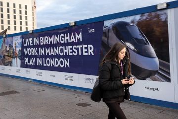 A woman walks in front of a billboard advertising HS2 A woman walks in front of a billboard advertising HS2