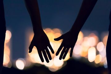 Two hands reach for each other, symbolising teaching and learning