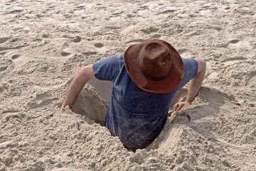 Man buried to waist in sand