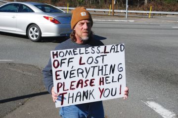 Homeless man on street corner holding sign Homeless man on street corner holding sign