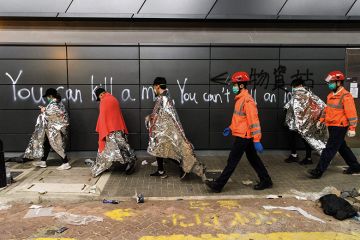Hong Kong students walk past graffiti Hong Kong students walk past graffiti