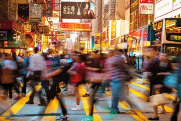 Motion Blurred Pedestrians walking over a busy crosswalk in Hong Kong