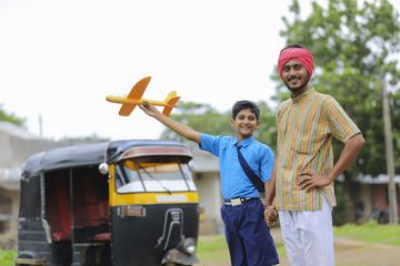 A young Indian rikshaw driver and his little brother holding a toy planeA young Indian rikshaw driver and his little brother holding a toy plane A young Indian rikshaw driver and his little brother holding a toy plane, symbolising international education