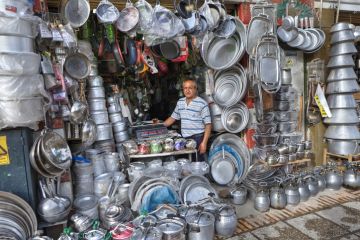 Iranian market trader with a large number of cooking pots, symbolising citations