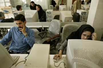 Iranian students on computers, illustrating online universities