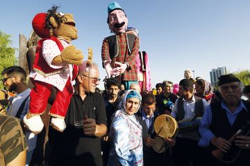 Iranians carry puppets as they gather at a park in the capital Tehran to celebrate Eid al-Adha  to illustrate Scholars doubt Iran’s 320,000 international students target