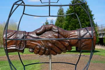 Christmas Truce Memorial showing soldiers handshake within a globe, National Memorial Arboretum.