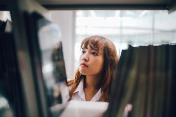 Woman searching books in library 