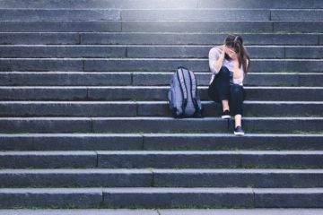 An upset woman sits alone on some steps An upset woman sits alone on some steps