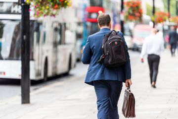 businessman man walking with briefcase and backpack before or after work.