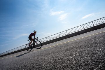 Cyclist cycling uphill on road