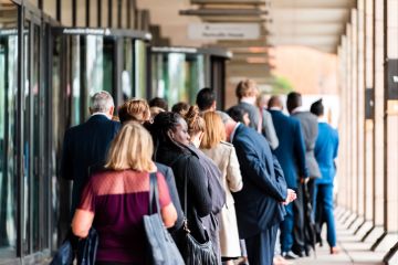People many crowd crowded standing in line queue to Westminster station