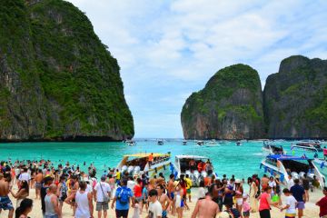 Famous crowded beautiful beach in Maya Bay. Maya Bay is closed due to damage to the coral reef by boats and intense tourism. Famous crowded beautiful beach in Maya Bay. Maya Bay is closed due to damage to the coral reef by boats and intense tourism.