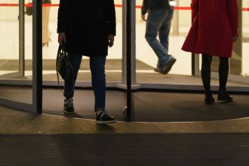 People leaving an office via a revolving door