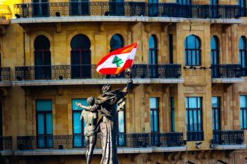 A statue of two people hugging with a Lebanese flag attached A statue of two people hugging with a Lebanese flag attached