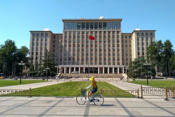 Students biking in front of the main entrance of Tsinghua University in Beijing, China.