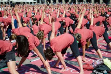 Crowd of women in pink shirts practicing stretching in the Plaza Mayor in Madrid capital of Spain