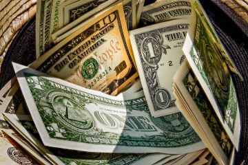 Straw hat with a stack of dollar bills inside Straw hat with a stack of dollar bills inside