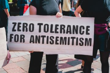 Protesters with a sign saying "Zero tolerance for antiseme=itism" Protesters with a sign saying "Zero tolerance for antisemitism"