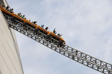 People riding rollercoaster at amusement park