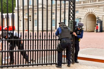 Police officers trying to close one of the gates of Buckingham Palace Police officers trying to close one of the gates of Buckingham Palace