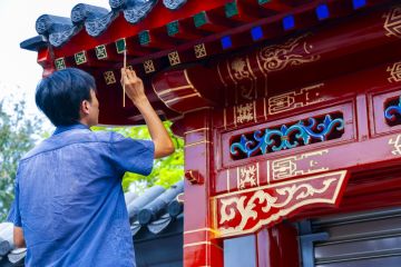 Chinese Man Painting Facade of SOuvenir Store near the Yonghegong Lama Temple Chinese Man Painting Facade of SOuvenir Store near the Yonghegong Lama Temple