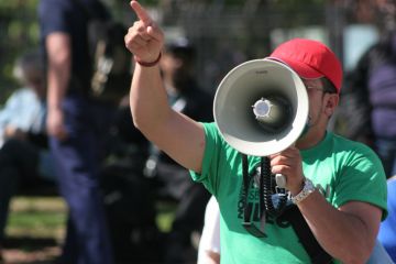 Protester pointing finger and holding megaphone Protester pointing finger and holding megaphone