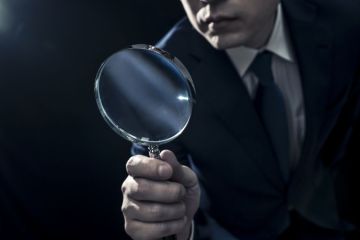 Businessman Peering Through Magnifying Glass Businessman Peering Through Magnifying Glass