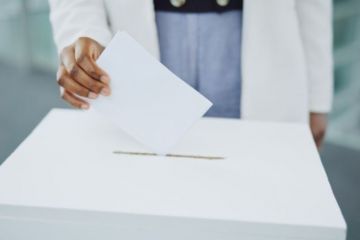 Hand, ballot and box for vote paper at president election cast, poll station choice or government selection.