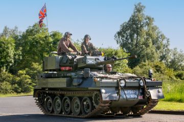  1974 CVR T SCIMITAR military vehicle driving on a British country road.
