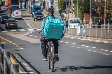 A Deliveroo cycle delivery worker on London street. A Deliveroo cycle delivery worker on London street.
