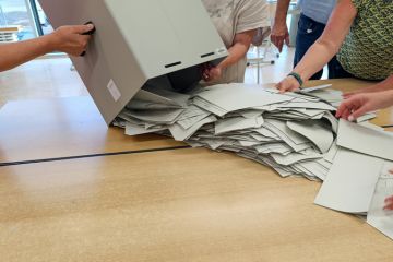 ballot papers are spread out from the ballot box for counting
