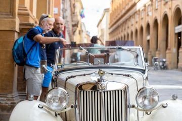 Two men admiring an MG T-Series car parked in the city centre in Bologna Two men admiring an MG T-Series car parked in the city centre in Bologna