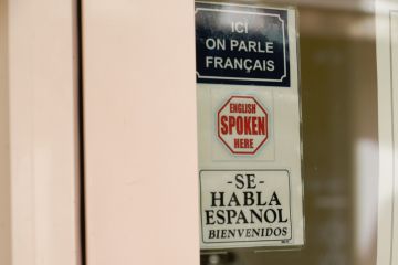 Sign reading 'Ici on parle francais; English spoken here; Se habla espanol'