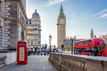 Red telephone box and double-decker bus on Parliament square and Big Ben tower,