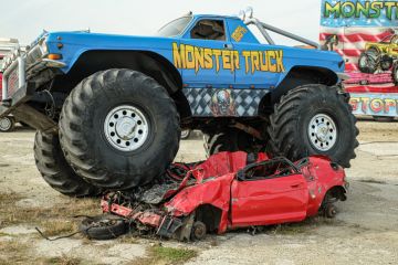 Huge Monster Truck climbs, crushes and completely destroys a demo car.