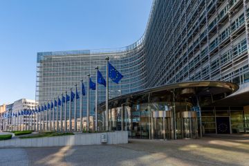 Entrance to the Berlaymont building, headquarters of the European Commission, with several EU flags lining the edge