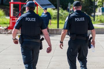 Police Officers Walking Through City Park Police Officers Walking Through City Park