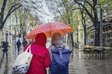 two women under one umbrella.