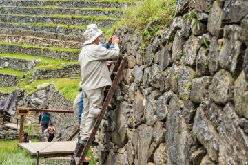 Conservation workers performing maintenance on the stone terrace walls at the Historic Sanctuary of Machu Picchu