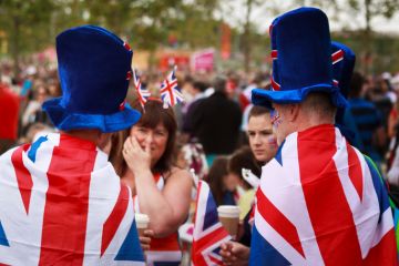 Unknown fans dressed in Union Jack flags and hats in the Olympic Park in Stratford, East London